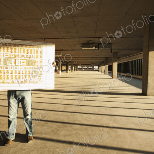 Businessman holding up plans for new office space standing in the middle of the empty… Businessman holding up plans for new office space standing in the middle of the empty…