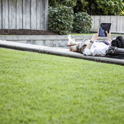 Businessman in a downtown city park taking a break and checking his compupter notebook Businessman in a downtown city park taking a break and checking his compupter notebook