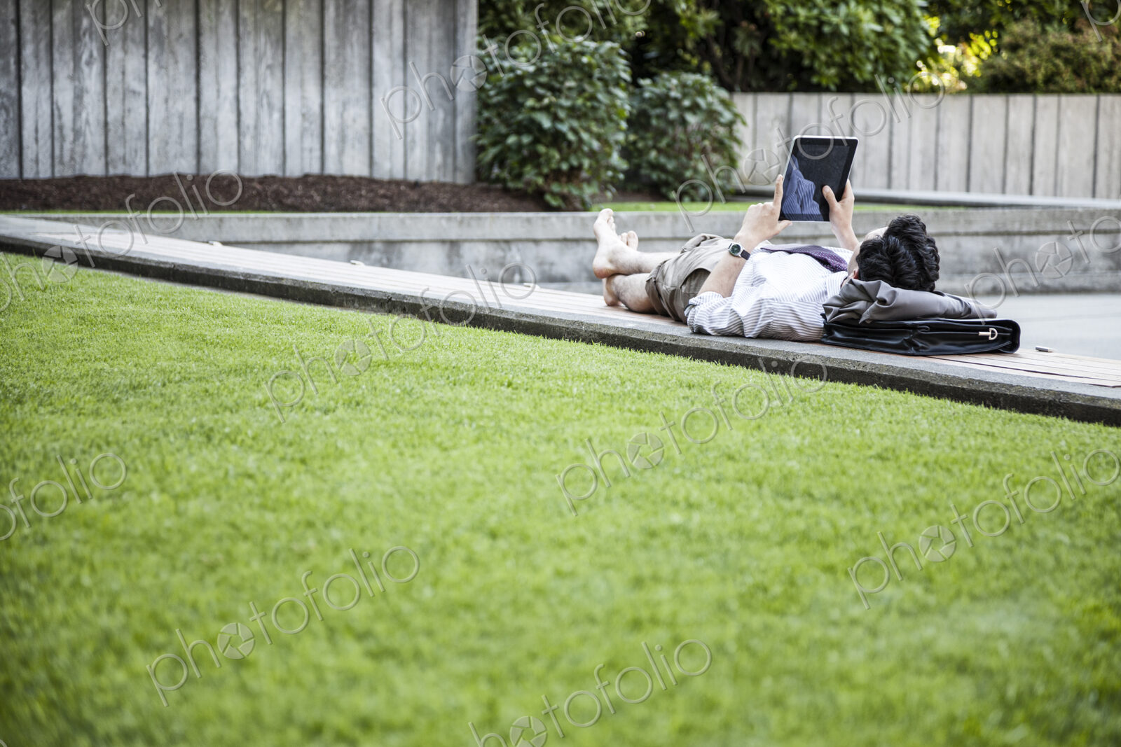 Businessman in a downtown city park taking a break and checking his computer notebook