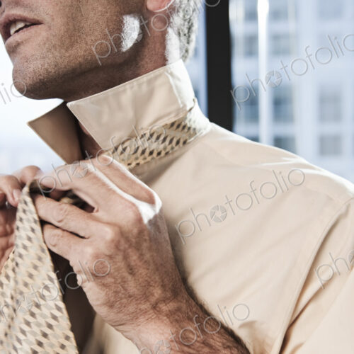 Businessman putting on a shirt and tie before work. Businessman putting on a shirt and tie before work.