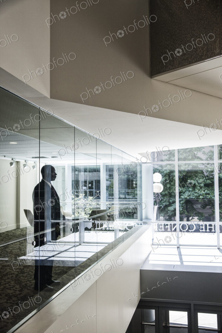 Businessman standing in a conference room window in a large business center.