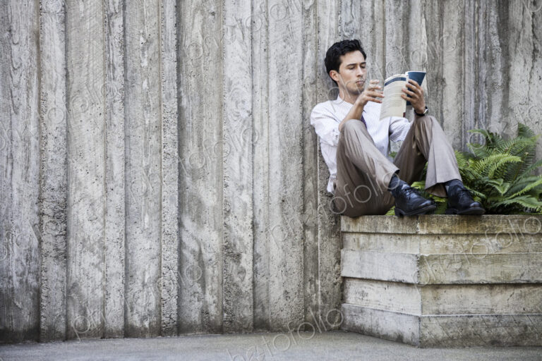 Businessman taking a break in a city park alcove.