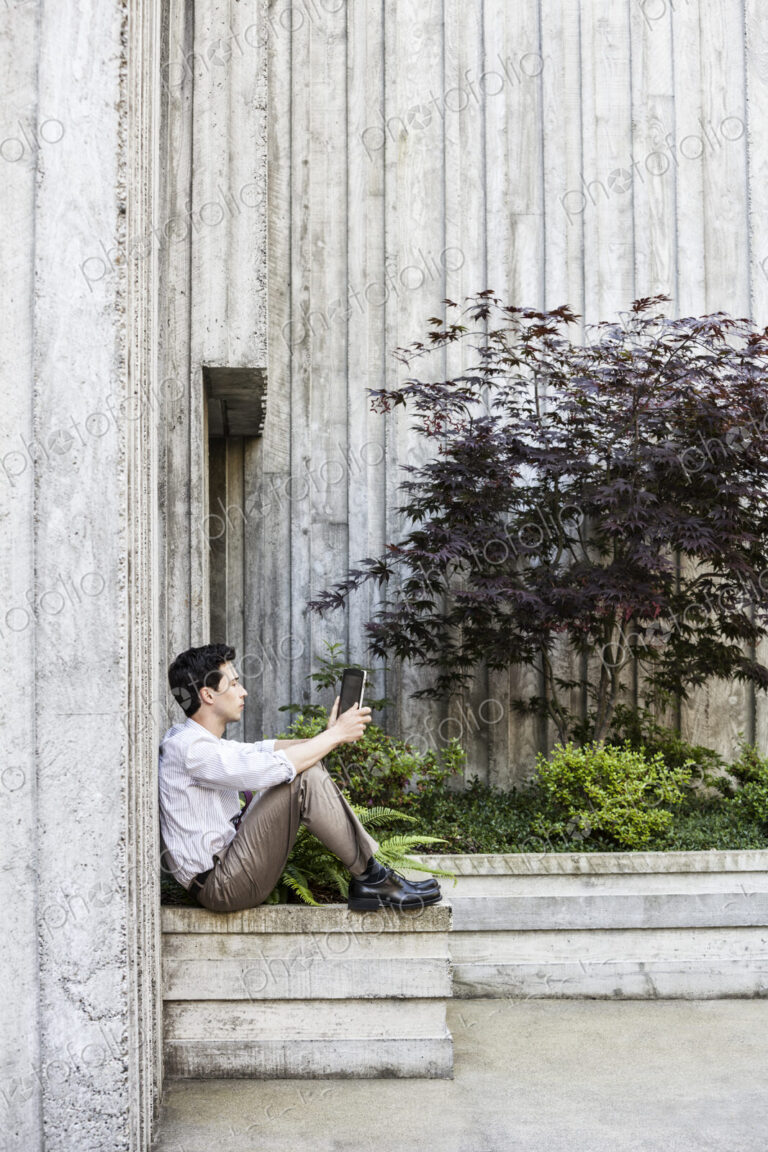 Businessman taking a break in a city park alcove.