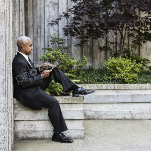 Businessman taking a break in a city park alcove. Businessman taking a break in a city park alcove.