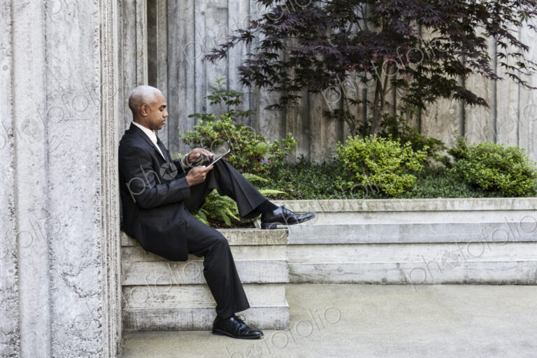 Businessman taking a break in a city park alcove.