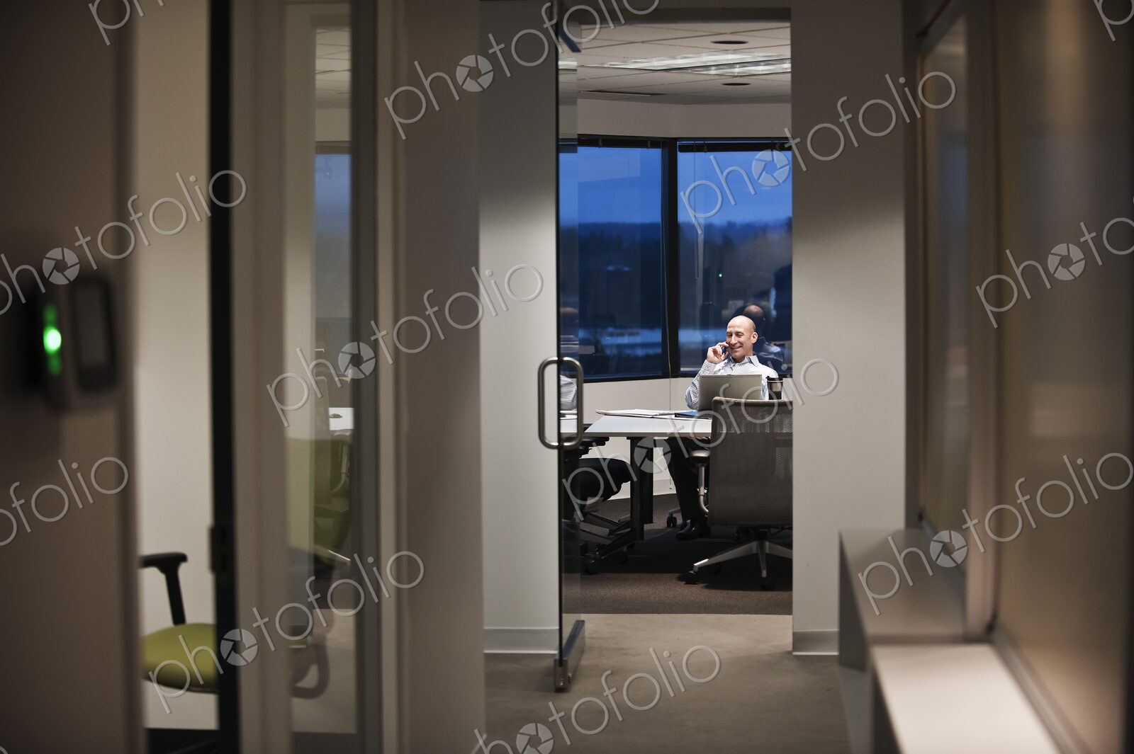 Businessman talking on the phone while working at night