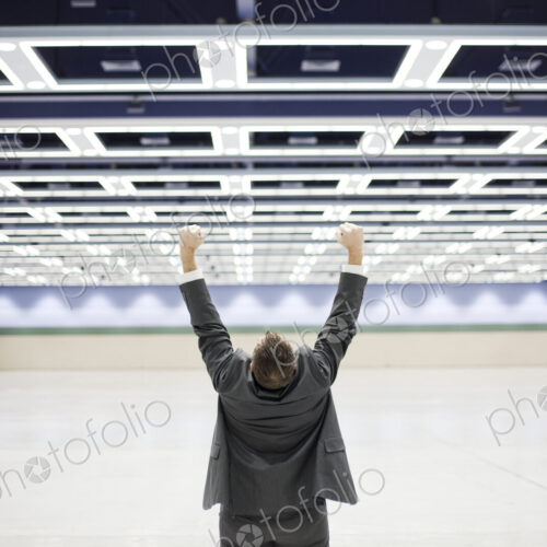 Businessman with his arms stetched in the air in open space celebrating