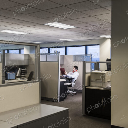 Businessman working in cubicle office. Businessman working in cubicle office.