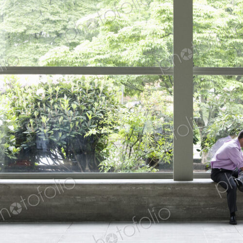 Businessman working on a notebook computer in front of a large window in a convention… Businessman working on a notebook computer in front of a large window in a convention…