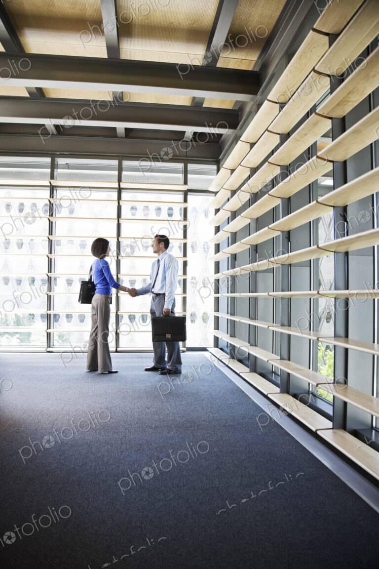 Businesswoman and busiinessman working in a lobby of a large office building.
