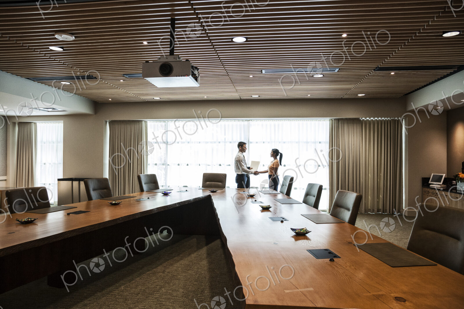 Businesswoman and man meeting in a large conference room.