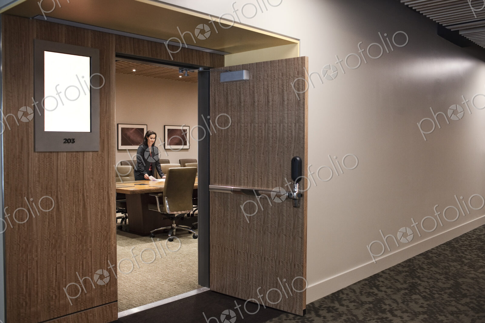 Businesswoman in a large conference room setting.