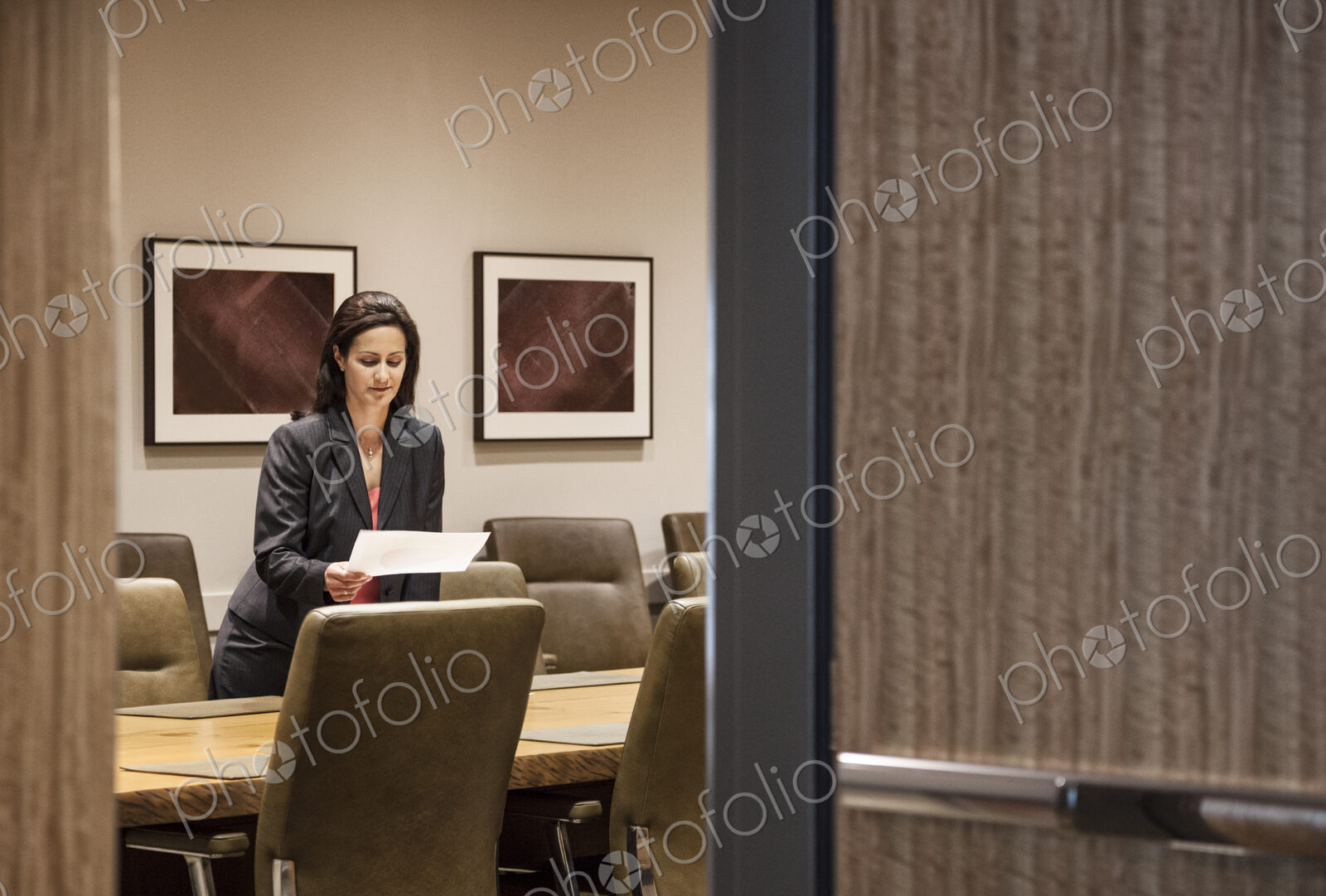 Businesswoman in a large conference room setting.