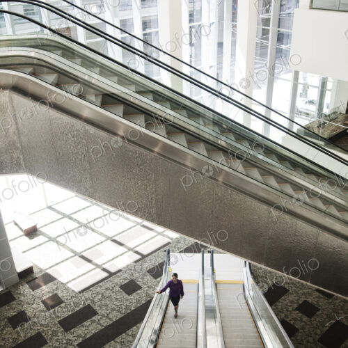 Businesswoman on an escalator in a large business center. Businesswoman on an escalator in a large business center.