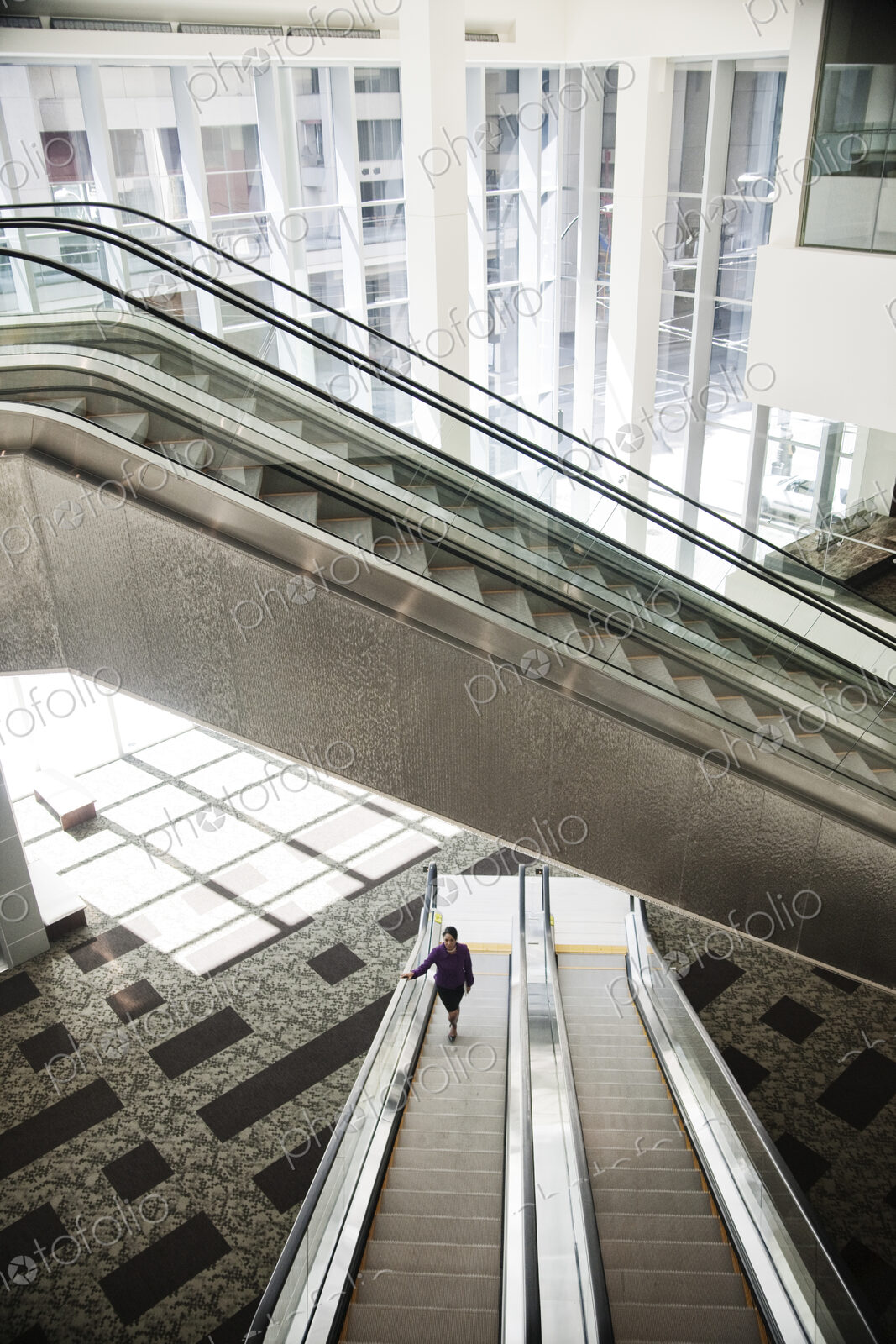 Businesswoman on an escalator in a large business center.
