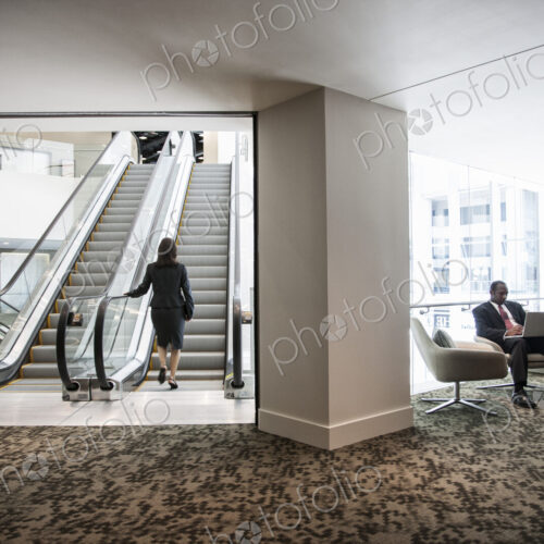 Businesswoman on an escalator in a large business center.