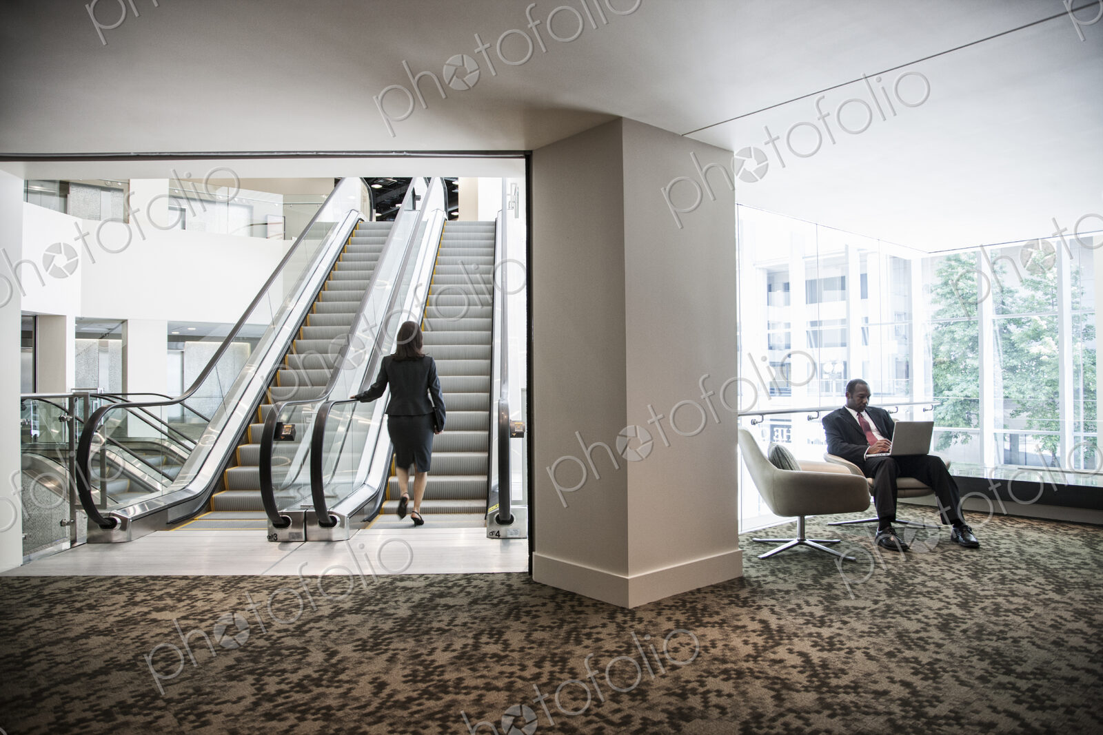Businesswoman on an escalator in a large business center.