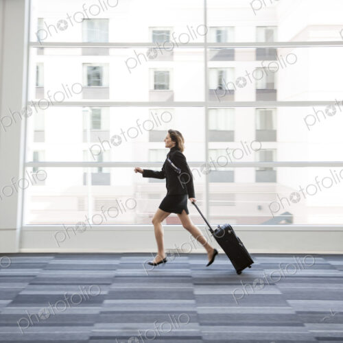 Businesswoman running through a conference centre lobby. Businesswoman running through a conference centre lobby.