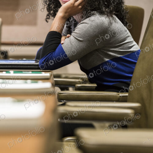 Businesswoman sitting at a conference table turning her head Businesswoman sitting at a conference table turning her head