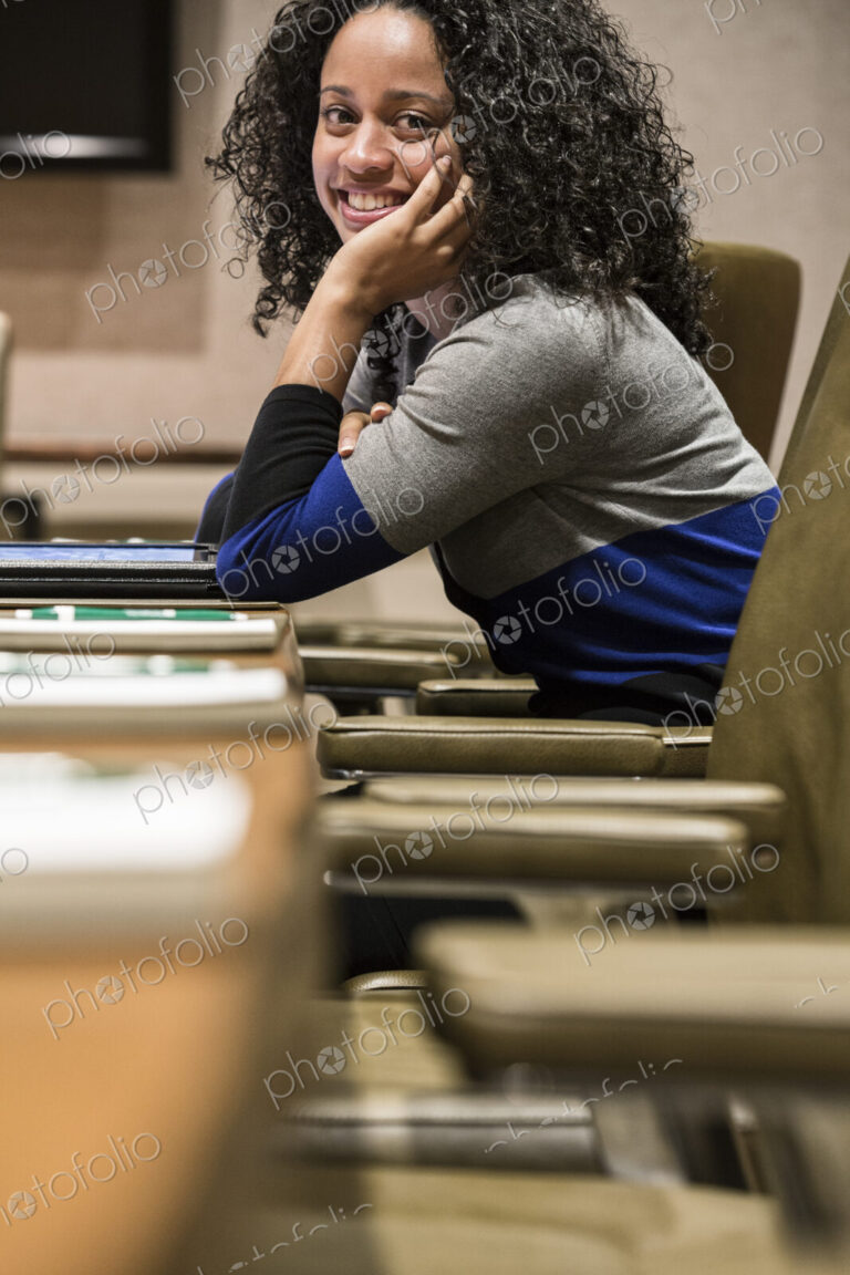 Businesswoman sitting at a conference table turning her head