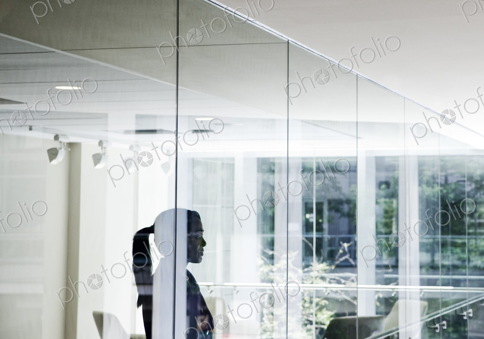Businesswoman standing in a conference room window in a large business center.