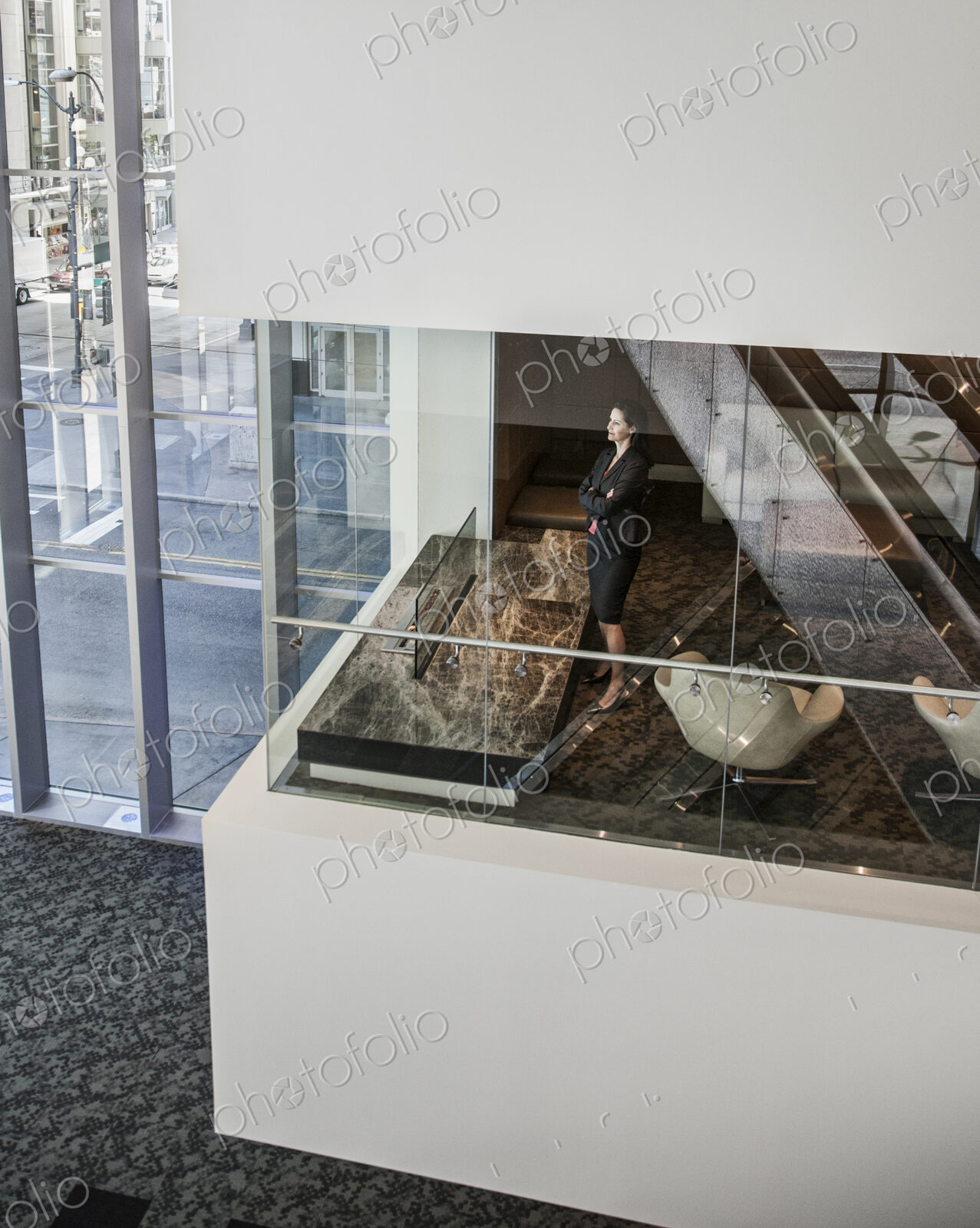 Businesswoman standing in a conference room window in a large business center.