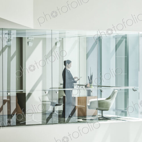 Businesswoman standing in a conference room window in a large business center. Businesswoman standing in a conference room window in a large business center.