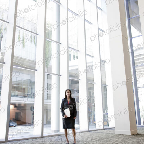 Businesswoman standing in the lobby of a large business center. Businesswoman standing in the lobby of a large business center.