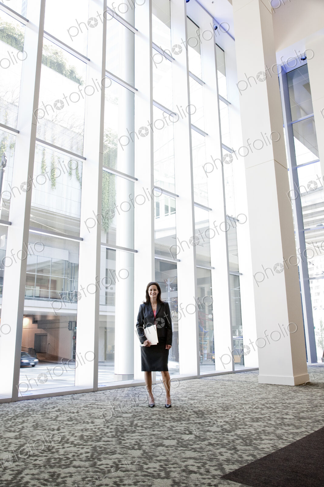 Businesswoman standing in the lobby of a large business center.