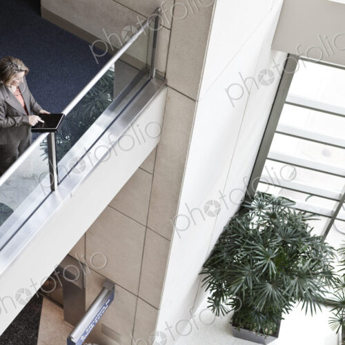 Businesswoman using a notebook computer in the lobby of a convention center.