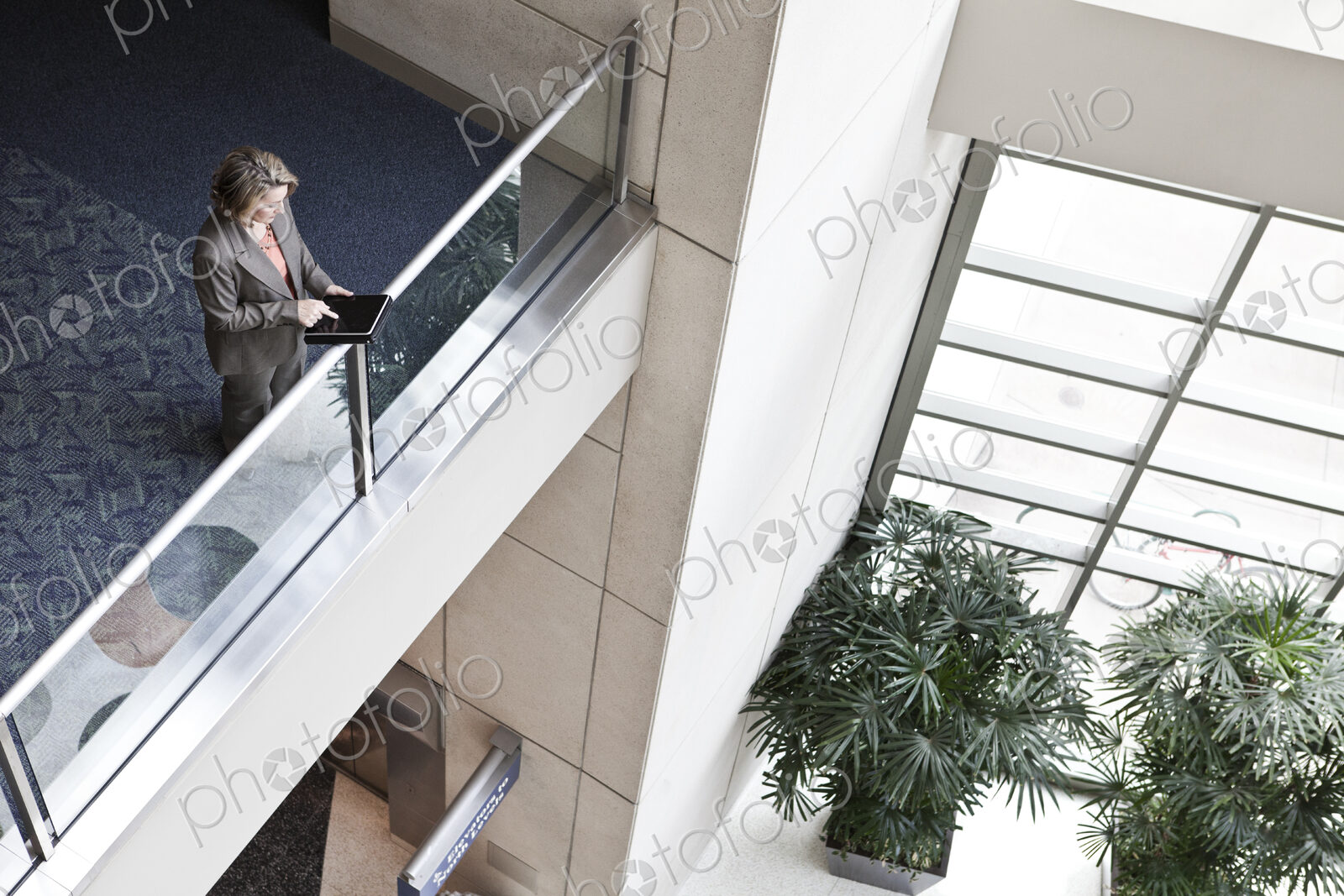 Businesswoman using a notebook computer in the lobby of a convention center.