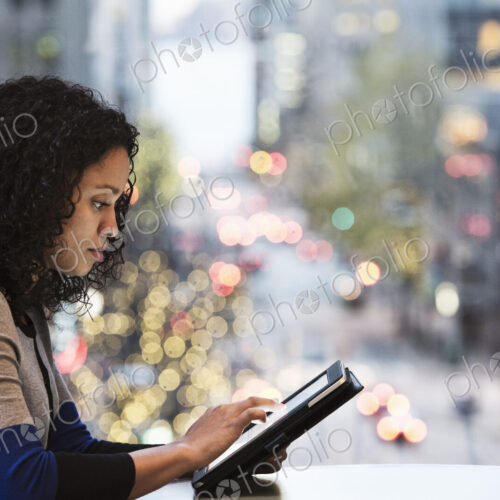 Businesswoman working on a notebook computer by a window with a city view Businesswoman working on a notebook computer by a window with a city view