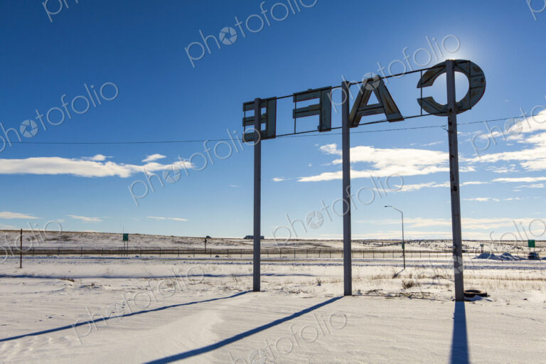 Cafe sign, red letters on posts beside the road, Ritzville.