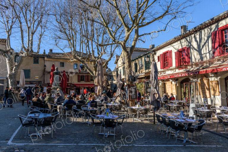 Cafe tables and chairs in a small square in Carcassonne lined with cafes.