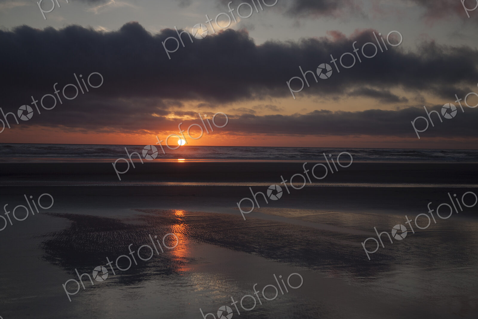 Cannon Beach with dramatic cloudy sky at sunset.