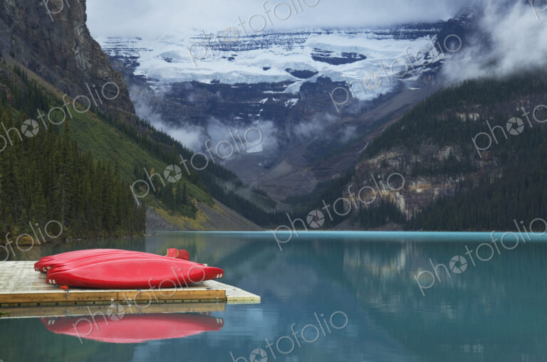 Canoes on wooden dock over still remote lake