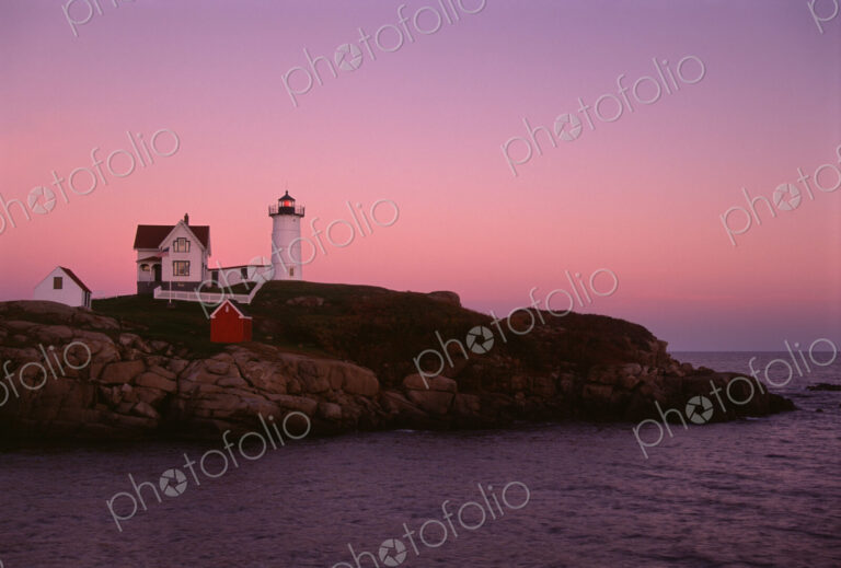Cape Neddick and the Nubble Lighthouse, on a headland on the Maine coastline at sunset.
