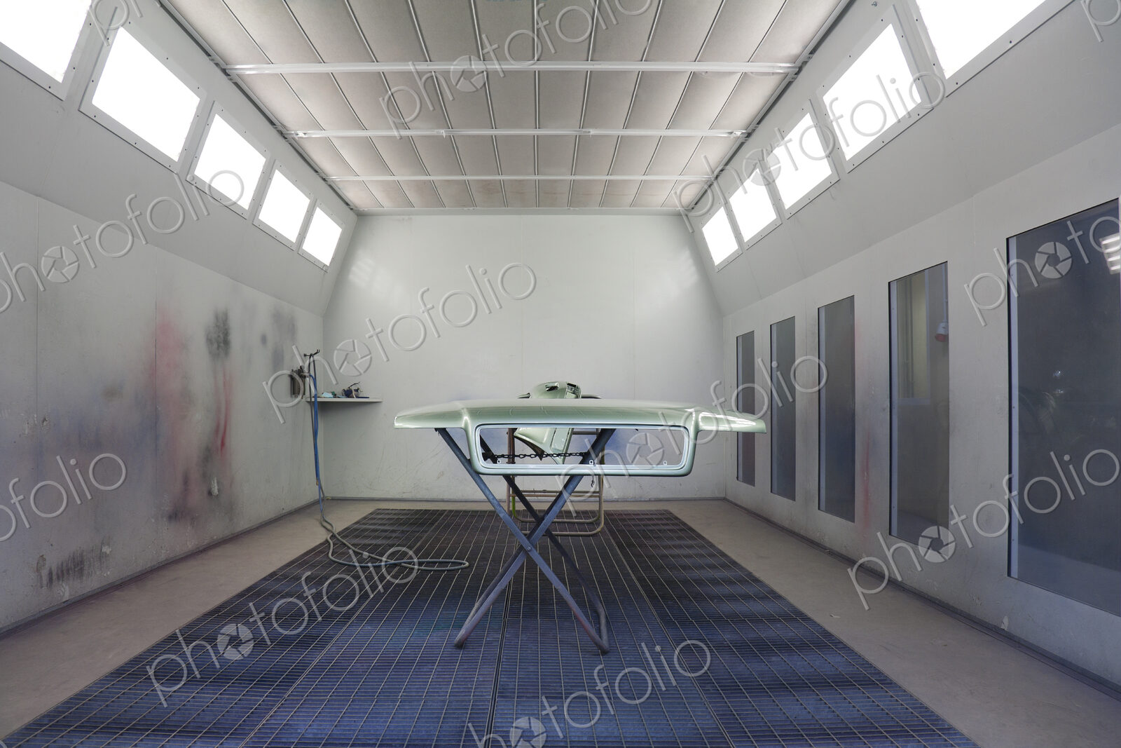 Car body part in enclosed body shop with spraying equipment