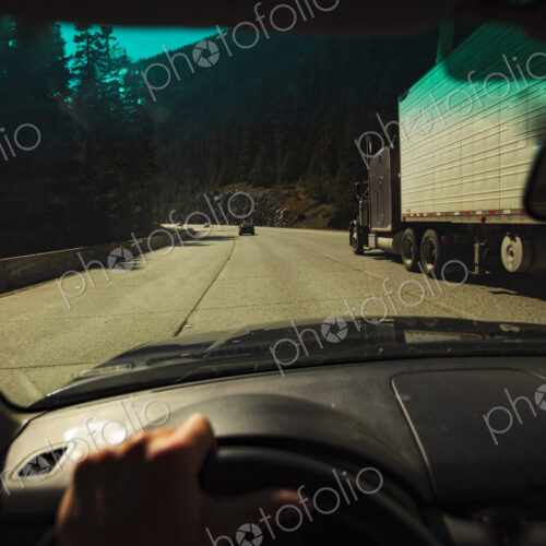 Car driver's windshield pov of multi-lane mountain highway with a semi truck,…
