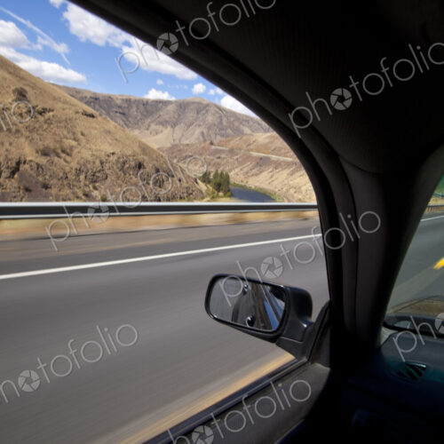 Car driving on road through Yakima River Canyon, Washington, United States Car driving on road through Yakima River Canyon, Washington, United States