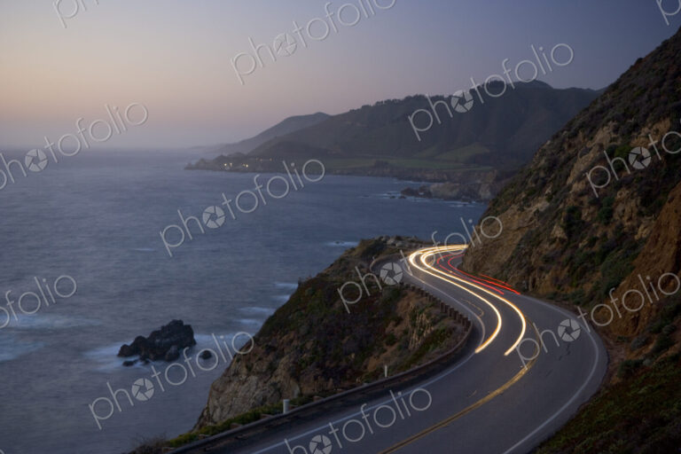 Car headlights on California Highway 1 south of the town of Carmel on the Big Sur…