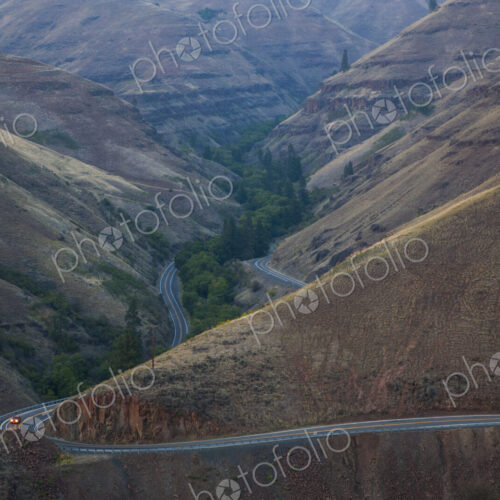 Car on the highway in an undulating landscape, valley and hillside