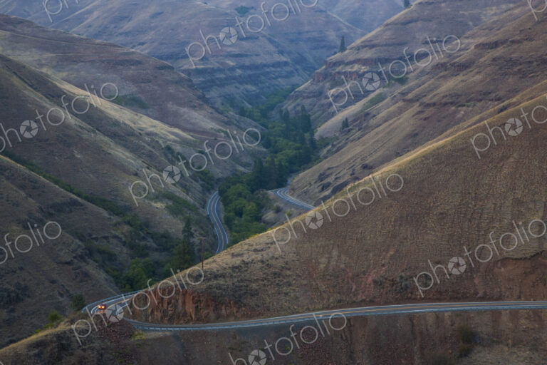Car on the highway in an undulating landscape, valley and hillside