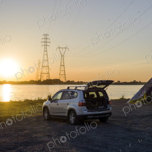 Car parked on rural lake shore Car parked on rural lake shore