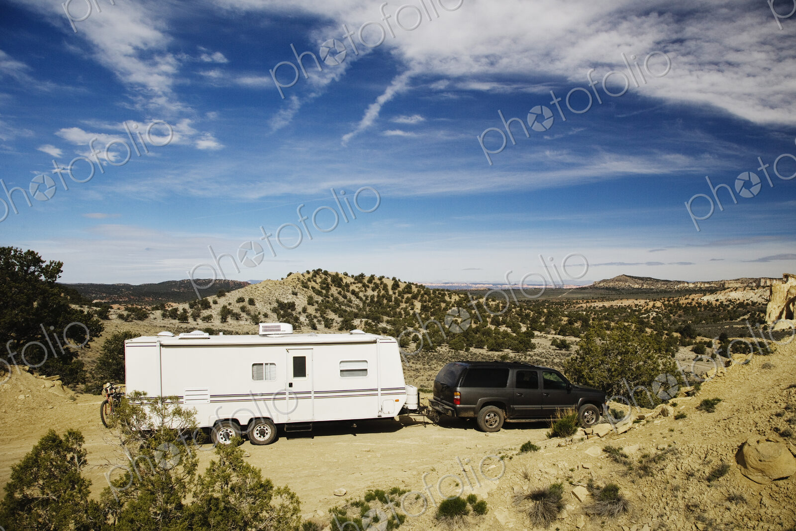 Car pulling trailer in desert landscape, Grand Staircase Escalante, Utah, United States