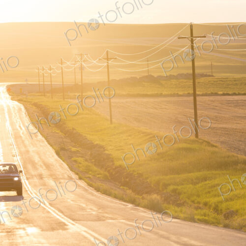 Car traveling on long straight open highway at sunset. Car traveling on long straight open highway at sunset.