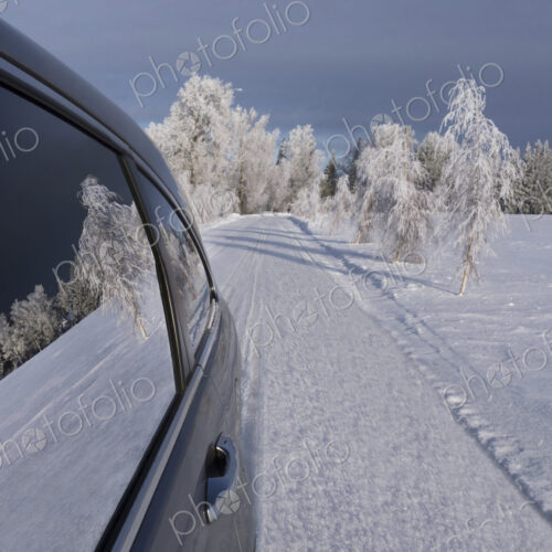Car with closed windows parked on a snowy road.