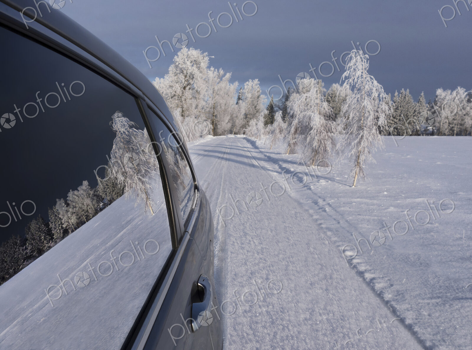 Car with closed windows parked on a snowy road.