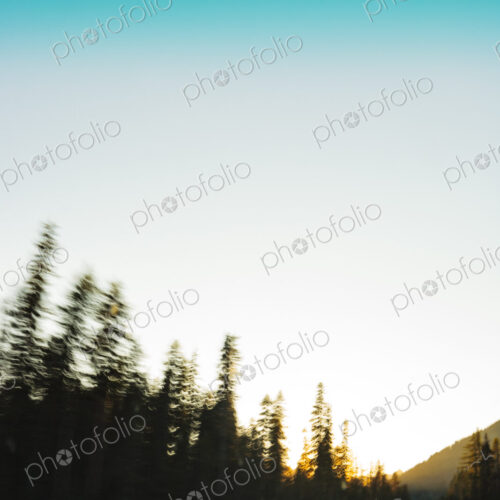 Car with headlights driving on a rural mountain highway at dusk. Car with headlights driving on a rural mountain highway at dusk.