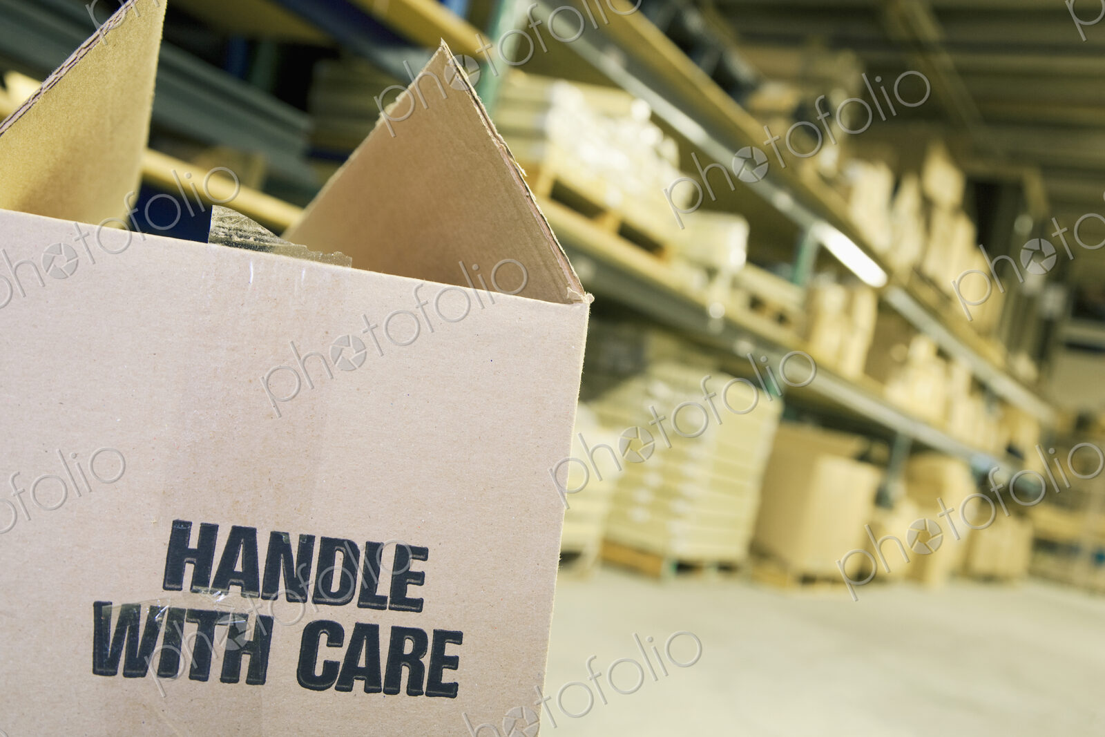 Carboard box in warehouse with shelves behind.